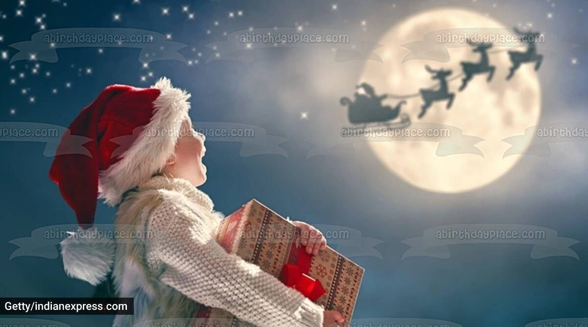 Feliz Navidad niño pequeño mirando renos adorno comestible para tarta imagen ABPID56799 